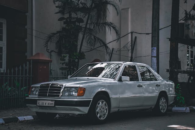 White Mercedes-Benz W124 500E parked on the street, showcasing its classic design