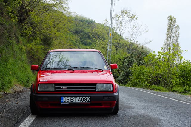 Red 1995 Volkswagen Jetta parked on a street, front view showcasing its classic design and headlights.